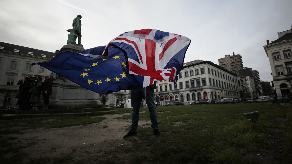 Pro-EU supporter Peter Cook unfurls a Union and EU flag prior to a ceremony to celebrate British and EU friendship outside the European Parliament in Brussels.