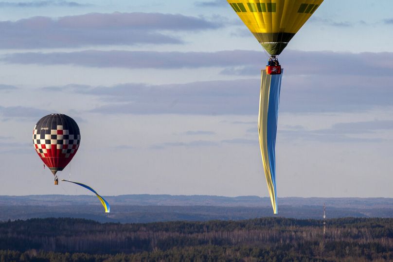Des montgolfières décorées de drapeaux nationaux ukrainiens flottent dans les airs lors de la manifestation contre l'invasion russe de l'Ukraine, à Vilnius, en avril 2022