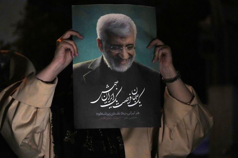 Un partisan du candidat iranien à la présidentielle Saeed Jalili brandit une affiche de Jalili lors de son étape de campagne à Téhéran, le 26 juin 2024