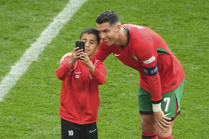 Un jeune envahisseur de terrain prend un selfie avec le Portugais Cristiano Ronaldo lors d'un match de groupe du tournoi de football Euro 2024 en Allemagne.