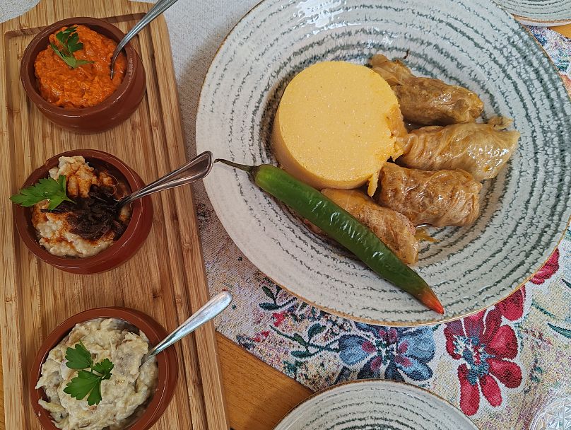 Au Gasthaus Altepost, je mange un festin roumain composé d'une trempette d'aubergines crémeuse, de rouleaux de feuilles de chou sarmale farcis de viande hachée et de trois variétés différentes de saucisses grillées.