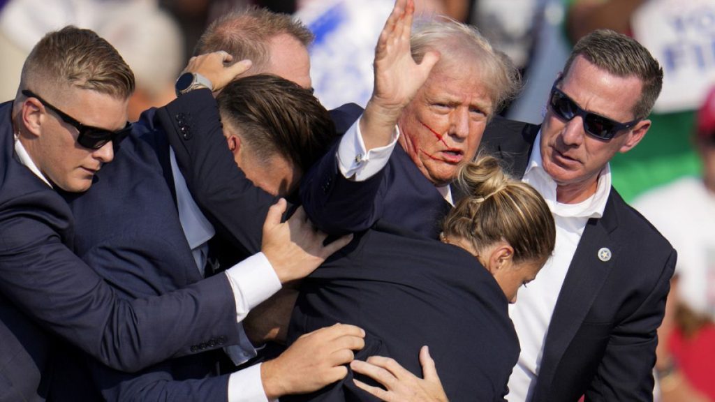 Republican presidential candidate former President Donald Trump is helped off the stage by U.S. Secret Service agents at a campaign event in Butler, Pa., on Saturday, July 13,