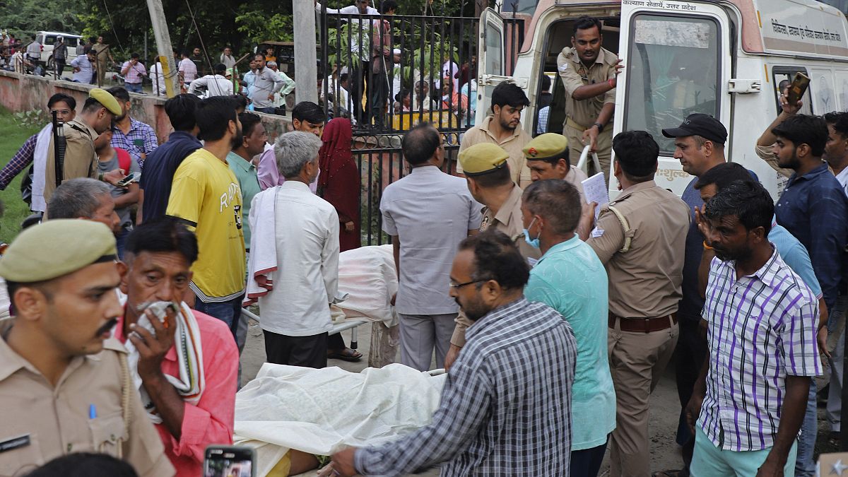 Relatives and volunteers carry the bodies on stretchers at the Sikandrarao hospital in Hathras district