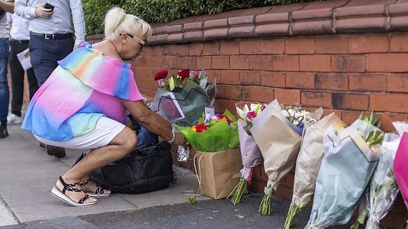 Une personne laisse des fleurs près de la scène à Hart Street, Southport