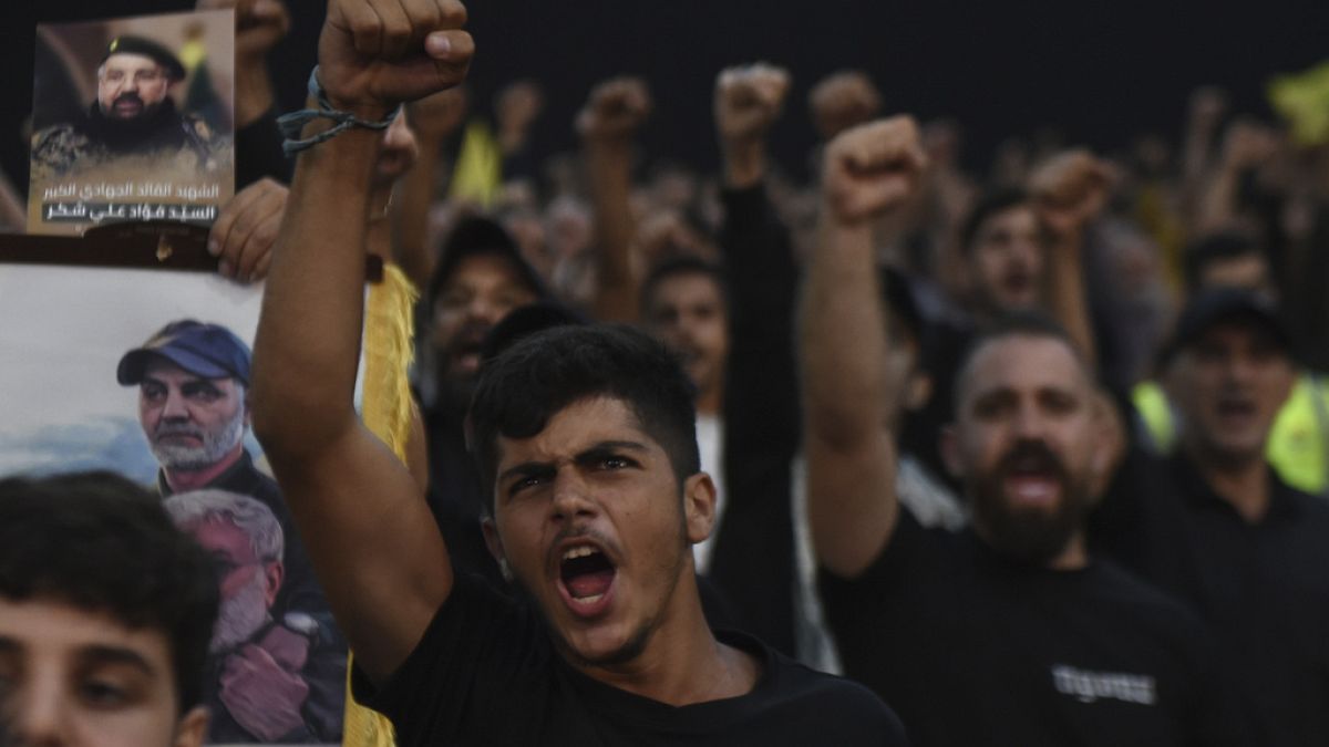 Supporters raise their fists and cheer as they watch a speech given by Hezbollah leader Sayyed Hassan Nasrallah on a screen in Beirut, Lebanon, Tuesday, Aug. 6, 2024.