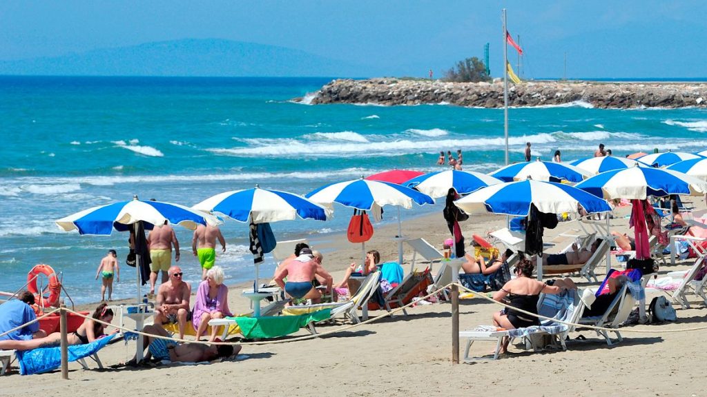 FILE - People enjoy a sunny day at an establishment on the beach in Tuscany