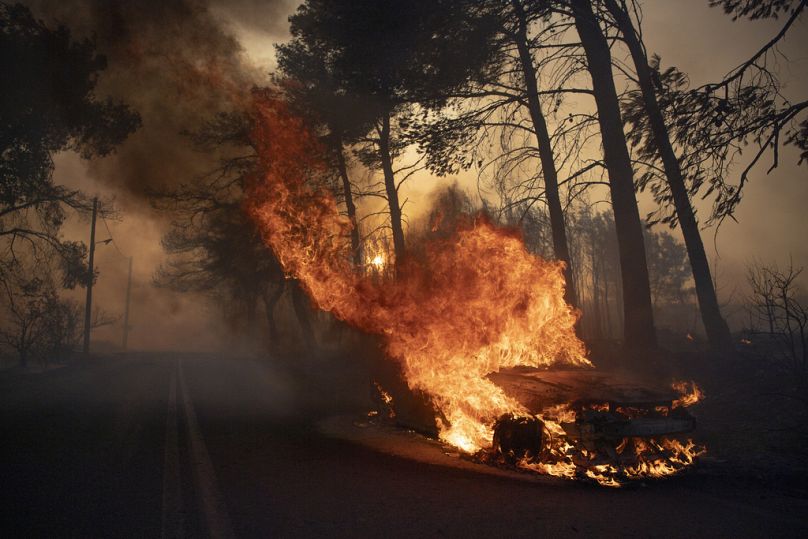 Une voiture brûle dans le village de Varnava lors d'un incendie de forêt à Athènes, en Grèce, le dimanche 11 août 2024.