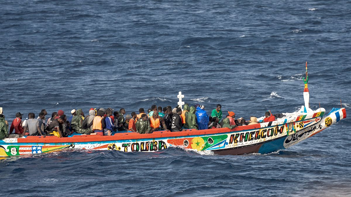 Migrants crowd a wooden boat as they sail to the port in La Restinga on the Canary island of El Hierro, Spain, Monday, Aug. 19, 2024.