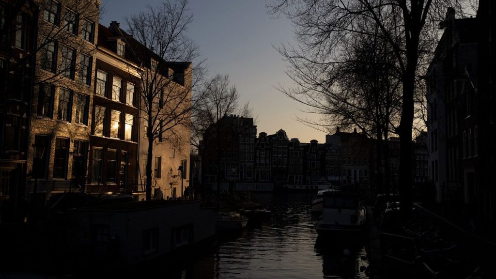 The setting sun bounces off a building in the Amsterdam city center skyline, Netherlands, Monday, Feb. 13, 2023.