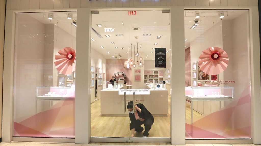 Tania Lima unlocks the glass doors opening a Pandora retail store in the Galleria Dallas mall in Dallas, Monday, May 4, 2020.