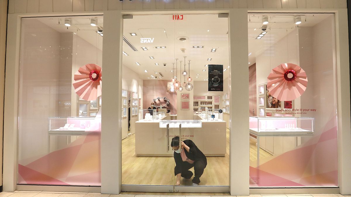 Tania Lima unlocks the glass doors opening a Pandora retail store in the Galleria Dallas mall in Dallas, Monday, May 4, 2020.