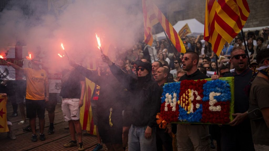Protesters hold independence flags and flares as they shout slogans calling for Catalonia