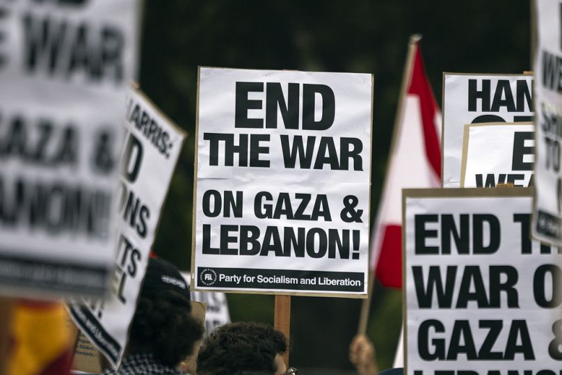 Un manifestant tient une affiche sur laquelle on peut lire