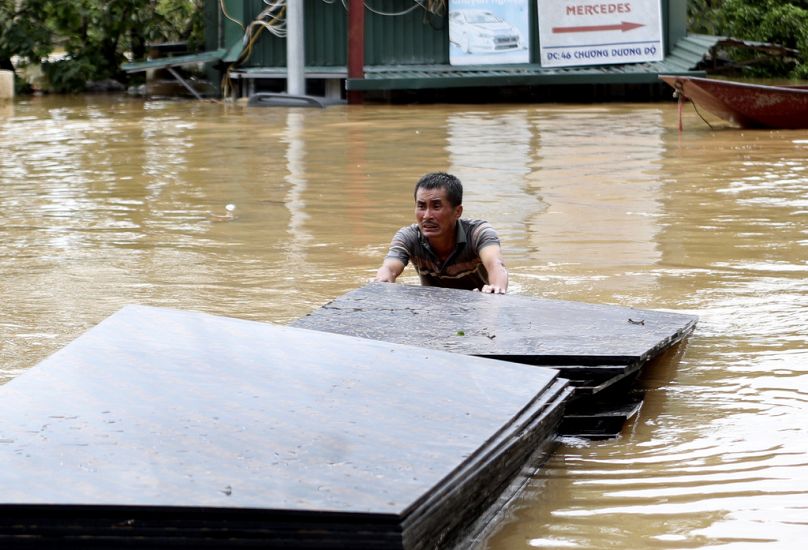 Un homme pousse une pile de contreplaqué dans les inondations qui ont suivi le typhon Yagi à Hanoi, au Vietnam.