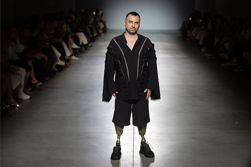Un vétéran de guerre ukrainien portant des prothèses défile pour présenter une tenue des créateurs Andreas Moskin et Andriy Bilous lors de la Fashion Week ukrainienne