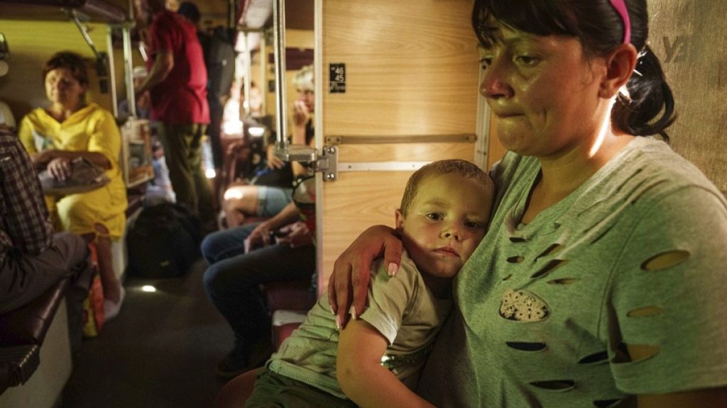 Alla hugs her son Ivan sitting in evacuation train in Pokrovsk, Donetsk region, Ukraine, Monday, Aug. 19, 2024.