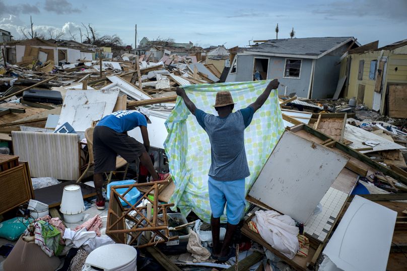 Des gens récupèrent leurs affaires dans les décombres de leurs maisons détruites, à la suite de l'ouragan Dorian à Abaco, aux Bahamas, en 2019.