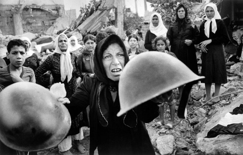 DOSSIER – Dans cette photo d'archive du 27 septembre 1982, une Palestinienne brandit des casques lors d'un service commémoratif à Beyrouth pour les victimes du massacre du camp de réfugiés de Sabra au Liban.