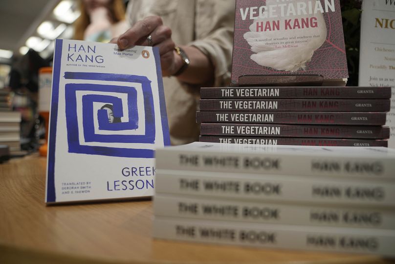 Un employé d'une librairie manipule des livres de l'écrivain sud-coréen Han Kang à Londres, le jeudi 10 octobre 2024.
