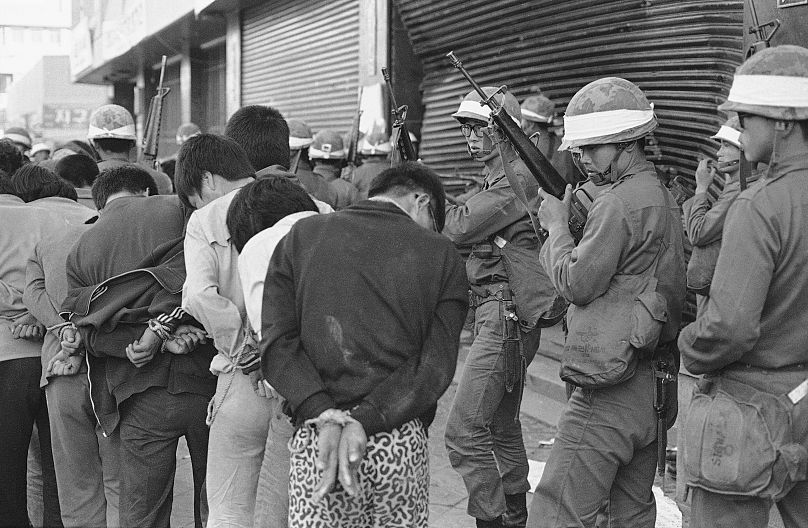 Des soldats armés du gouvernement sud-coréen emmènent les rebelles capturés vers un point de rassemblement dans la ville de Gwangju (Kwangju), en Corée du Sud, ravagée par les émeutes, le 27 mai 1980.