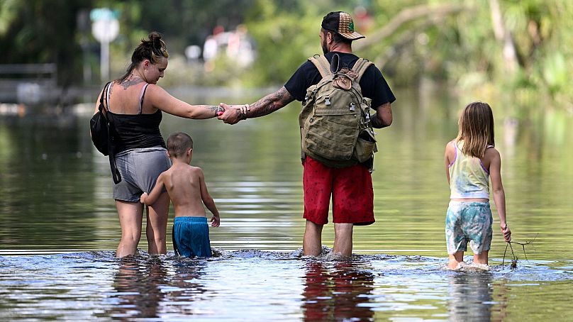 Dustin Holmes, Hailey Morgan et ses enfants retournent dans leur maison inondée à la suite de l'ouragan Helene, le 27 septembre 2024, à Crystal River, en Floride.