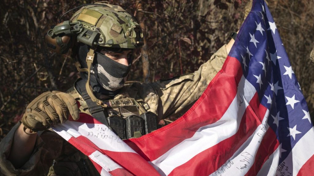 A volunteer fighter from the U.S. state of Texas who serves with the 23rd rifle battalion of Ukraine’s armed forces, holds a U.S. flag in the Kharkiv region, Oct. 26, 2024.