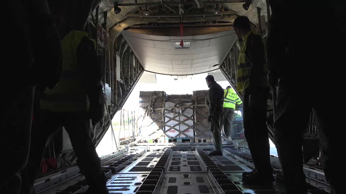 Workers load aid aboard a military plane at an airfield in Pisa, 16 November, 2024