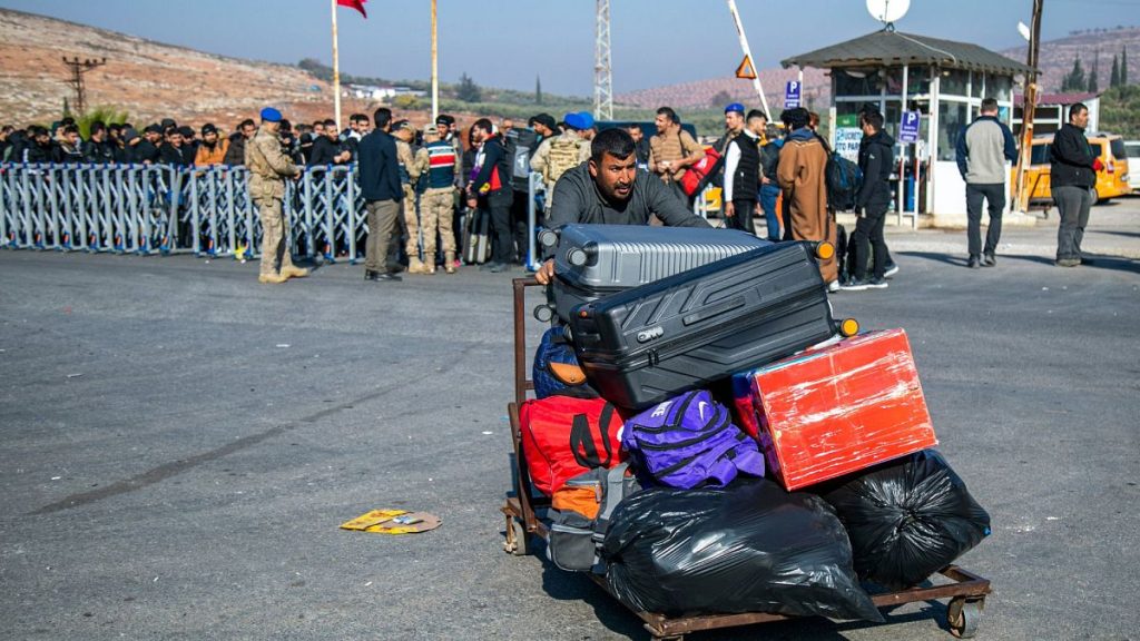 Syrians arrive to cross into Syria from Turkey at the Cilvegozu border gate, near the town of Antakya, southern Turkey, Monday, 9 December 2024.