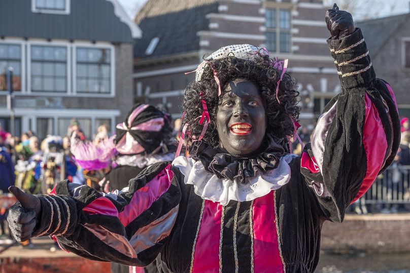 Black Pete interagit avec les enfants lors de l'arrivée de Sinterklaas à Monnickendam, aux Pays-Bas.