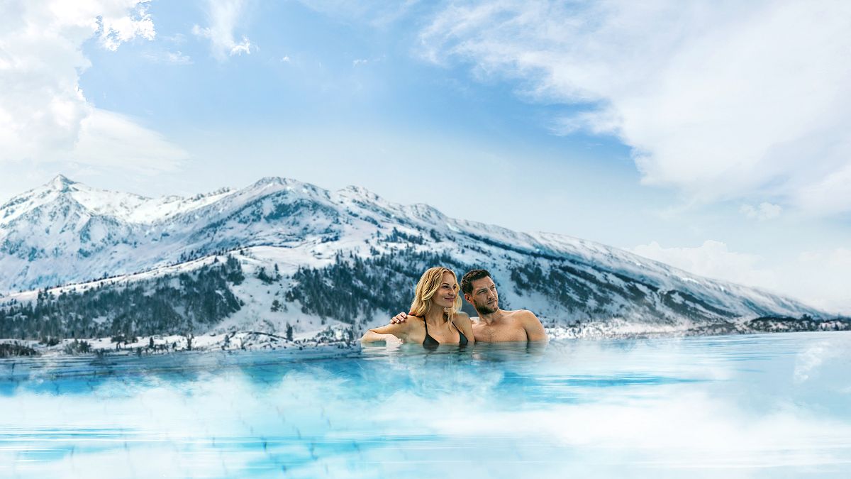A ski-free winter alpine escape: Couple in an outdoor pool
