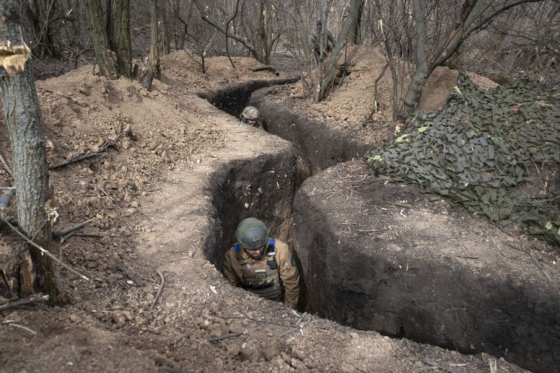 Des militaires ukrainiens de la 28e brigade mécanisée séparée prennent position dans une tranchée sur la ligne de front, près de Bakhmut, mars 2024.
