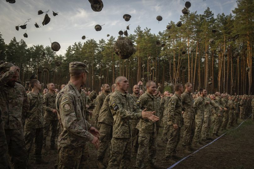 Des soldats nouvellement recrutés crient des slogans alors qu'ils célèbrent la fin de leur entraînement dans une base militaire près de Kiev, en Ukraine, le lundi 25 septembre 2023.