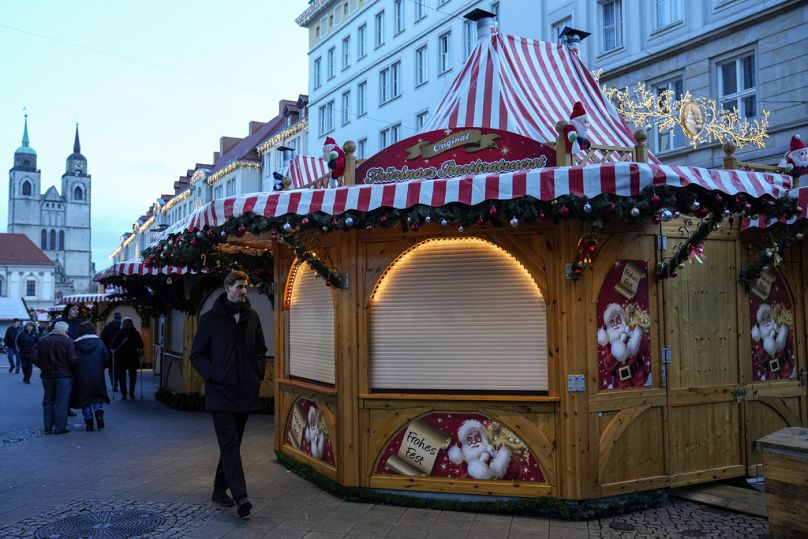 Des gens marchent au marché de Noël, où une voiture a foncé sur la foule vendredi soir, à Magdebourg, en Allemagne, le dimanche 22 décembre 2024.