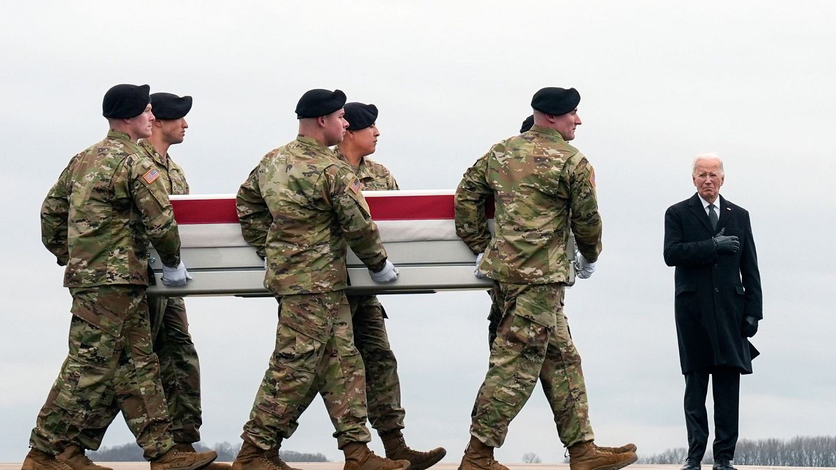 President Joe Biden, right, stands as an Army carry team moves the transfer case containing the remains of U.S. Army Sgt. Kennedy Ladon Sanders, 24, on 2 Feb 2024.