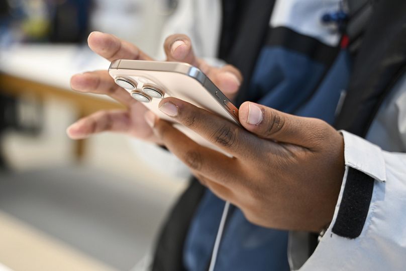Un homme regarde le nouvel iPhone 16 dans l'Apple Store sous le nom d'iPhone 16 doté d'un logiciel d'intelligence artificielle, le 20 septembre 2024