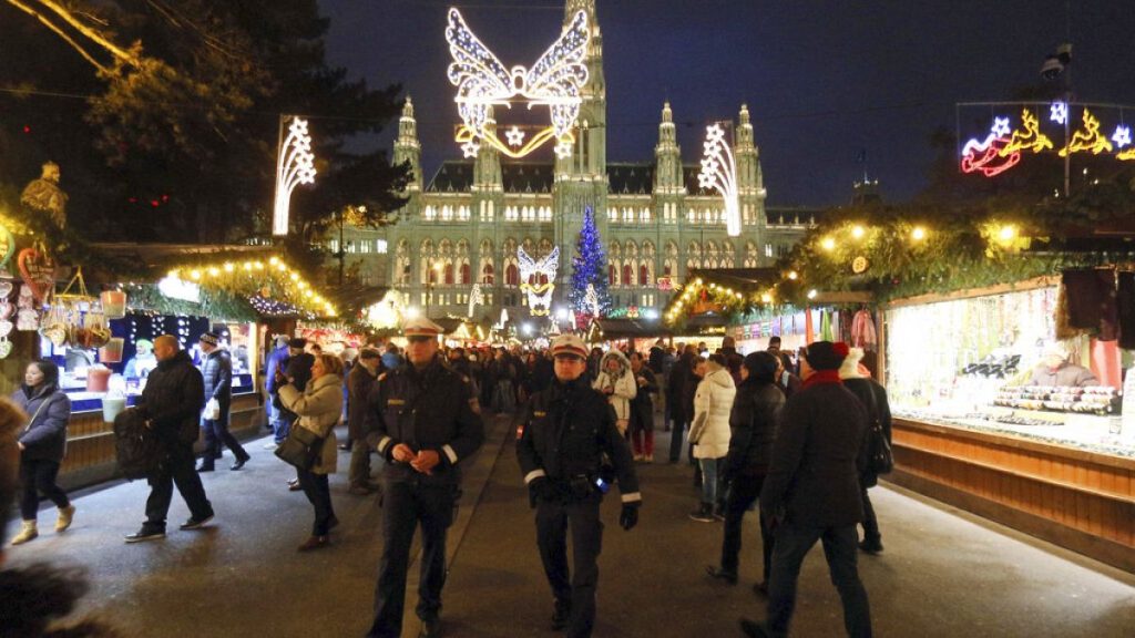 Two police officers patrol on the Viennese Christmas Market with the Viennese city hall in Vienna, Austria, Friday, Nov. 27, 2015.