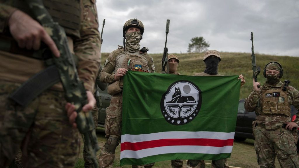 Volunteer soldiers pose with a flag of Chechen Republic of Ichkeria after a training outside Kyiv, Ukraine, Saturday, 27 August 2022.