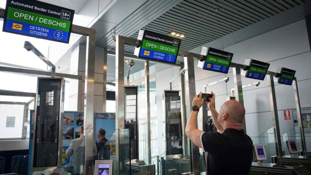 A man takes a picture of Non-Schengen automatic border control gates, at the Henri Coanda International Airport in Otopeni, near Bucharest, Romania, Thursday, March 28, 2024.