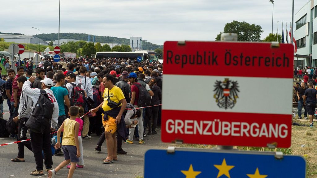 Migrants queue up for buses after they arrived at the border between Austria and Hungary about 180 kms (110 miles) south of Vienna, Austria, Saturday, Sept. 19, 2015.