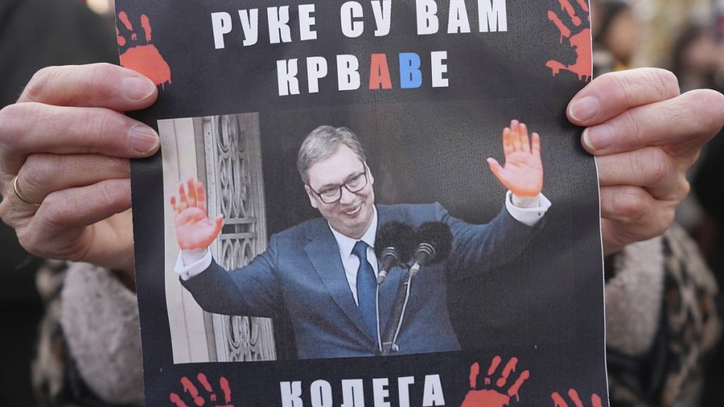 A woman holds up a sign showing Serbian President Aleksandar Vučić and the words