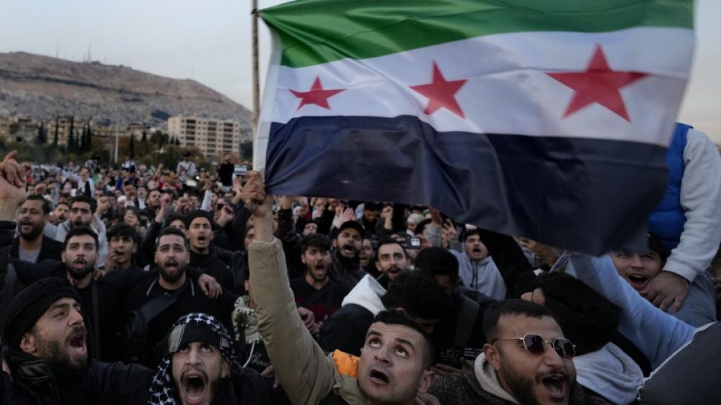 Syrian citizens wave the revolutionary flag and shout slogans, as they celebrate during the second day of the take over of the city by the insurgents in Damascus, Syria, Monda