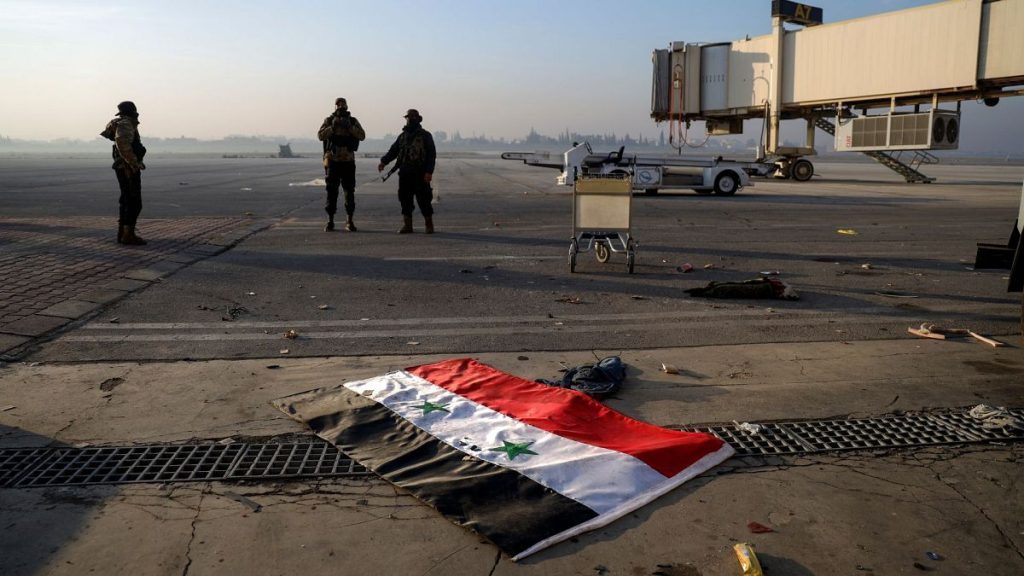 Syrian opposition fighters stand atop a seized Syrian Air Force fighter plane at the Hama military airport, Syria, Friday 6 Dec 2024.