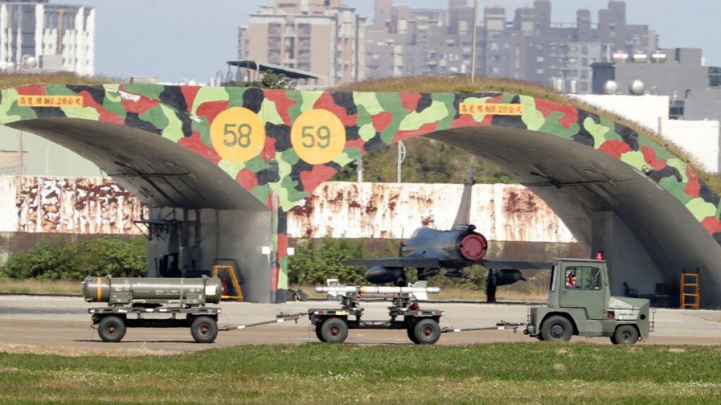 Taiwanese air ground troop vehicle moves past airplane fort at an airbase in Hsinchu, northern Taiwan, Wednesday, Dec. 11, 2024.