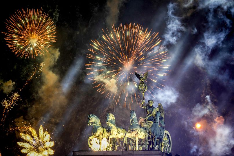 Des feux d'artifice illuminent le ciel au-dessus du Quadriga à la porte de Brandebourg lors des célébrations du Nouvel An peu après minuit à Berlin, en Allemagne, le mercredi 1er janvier 2025.