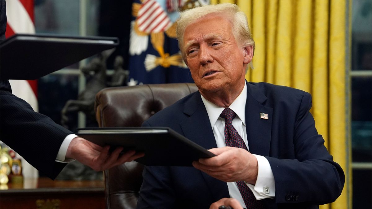 President Donald Trump signs executive orders in the Oval Office of the White House.