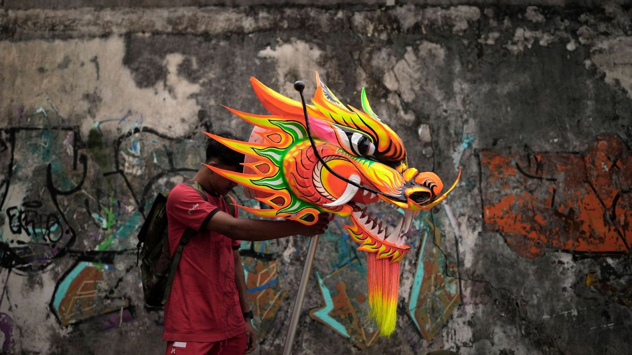 Un membre du Dragon Dance Club Naga Merah Putih (Red White Dragon) qui porte le nom des couleurs nationales indonésiennes, tient la tête d'une marionnette de dragon