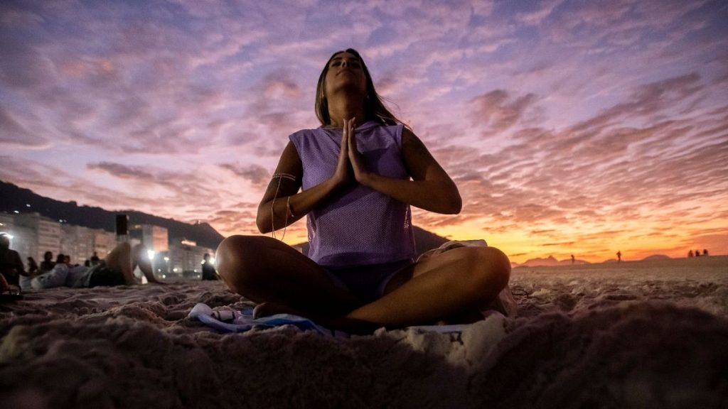 A woman sits in lotus prayer pose during the