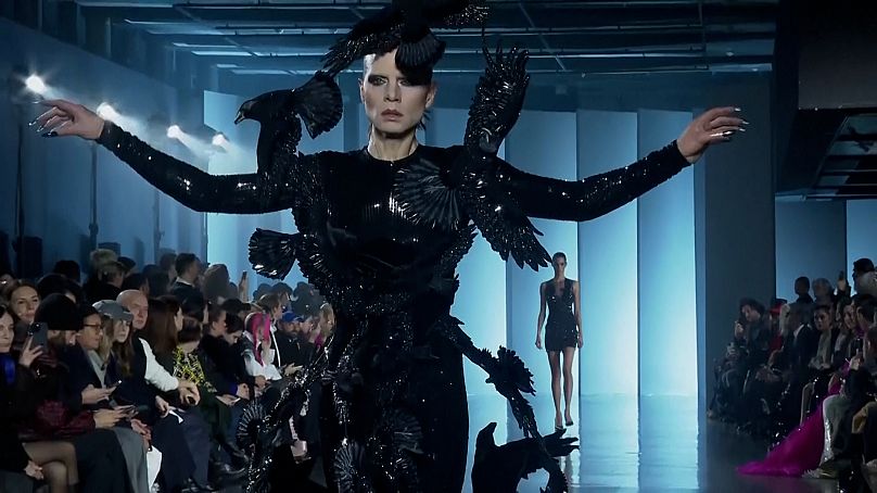 Un modèle prend son envol dans une création inspirée de Raven au Cosmic Couture Show de Rahul Mishra à Paris.