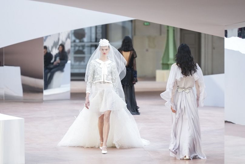 Un modèle orne la piste dans une création inspirée de la mariée de la collection Haute Couture Spring / été 2025 de Chanel.