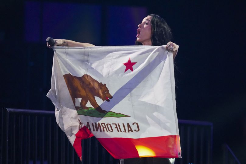Katy Perry se produit lors du concert de prestations Fireaid, tenant le drapeau de la Californie. 